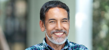 Man looking up from computer with smile